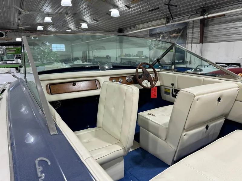 Slide: The Image of Interior of a 1998 Century Coronado boat with white seats and wooden dashboard. - 6