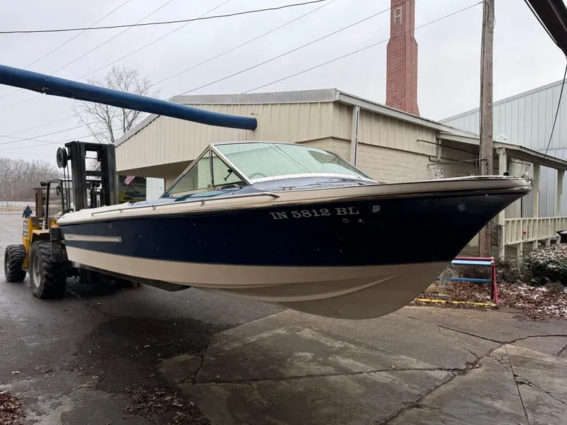 Slide: The Image of 1998 Century Coronado boat on forklift, blue and white, outdoors near industrial building. - 8