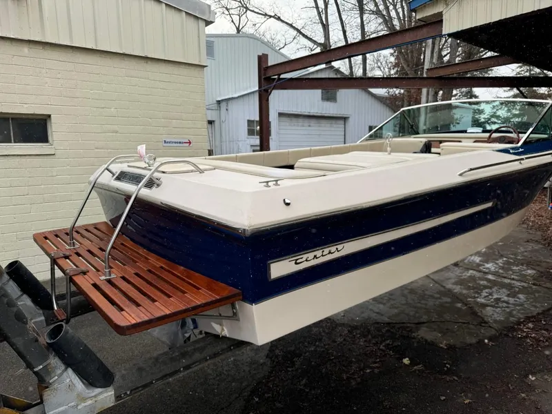 Slide: The Image of 1998 Century Coronado boat with wooden deck, parked near garages. - 9