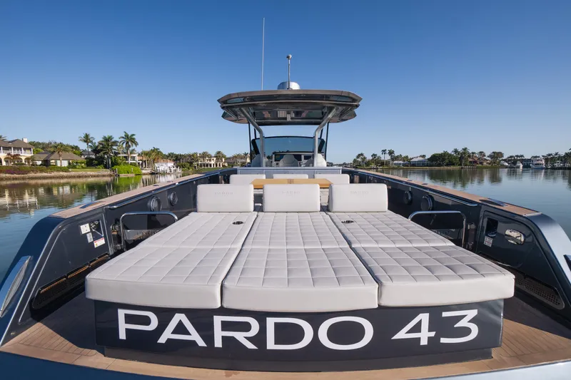 Slide: The Image of 2025 Pardo Yachts P43 luxury yacht with sunbathing area, docked on a serene waterfront. - 19