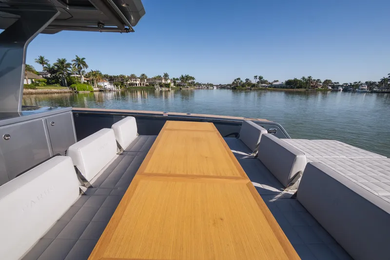Slide: The Image of 2025 Pardo Yachts P43 deck with seating and table, overlooking serene waterfront view. - 24