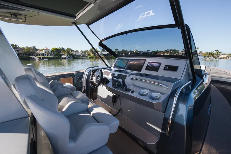 Slide: The Image of 2025 Pardo Yachts P43 helm with modern controls and luxurious seating on a serene waterway. - 32