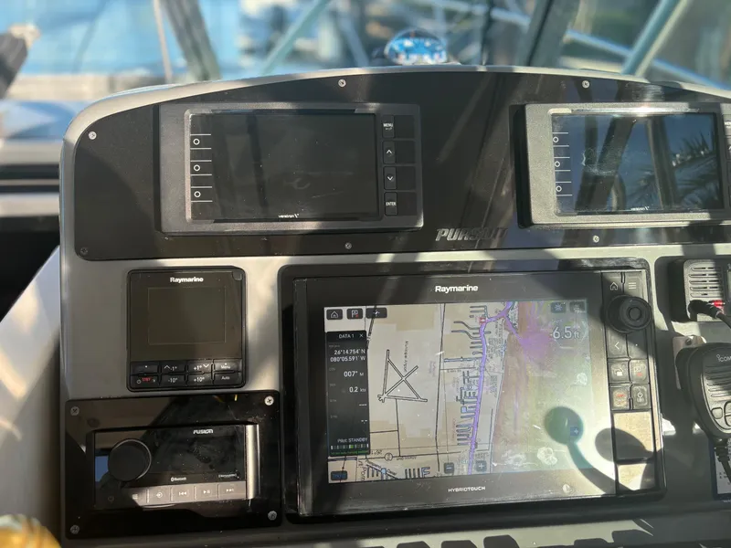Slide: The Image of Control panel of 2000 Pursuit 3400 Express boat with navigation screens and instruments. - 11