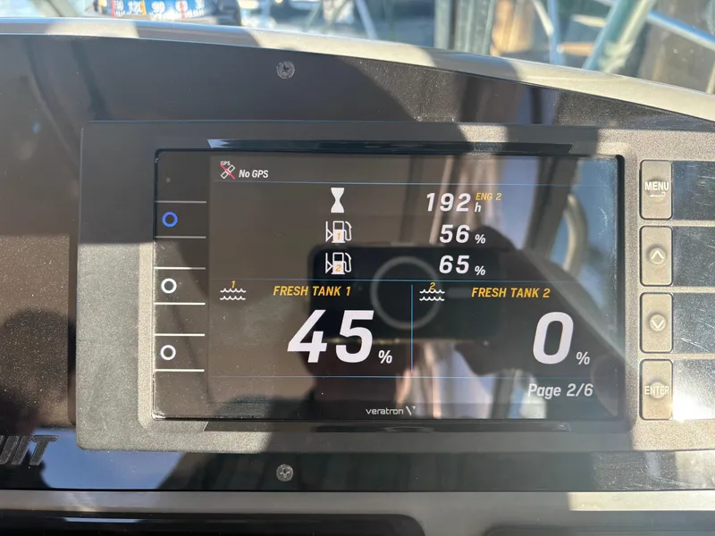 Slide: The Image of Boat dashboard display showing engine hours and tank levels on a 2000 Pursuit 3400 Express. - 14