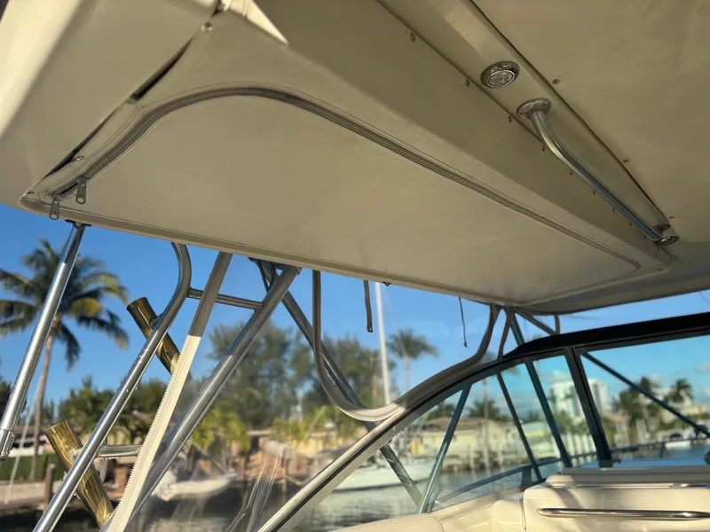 Slide: The Image of Pursuit 3400 Express boat tower, 2000 model, with clear sky and palm trees in background. - 16