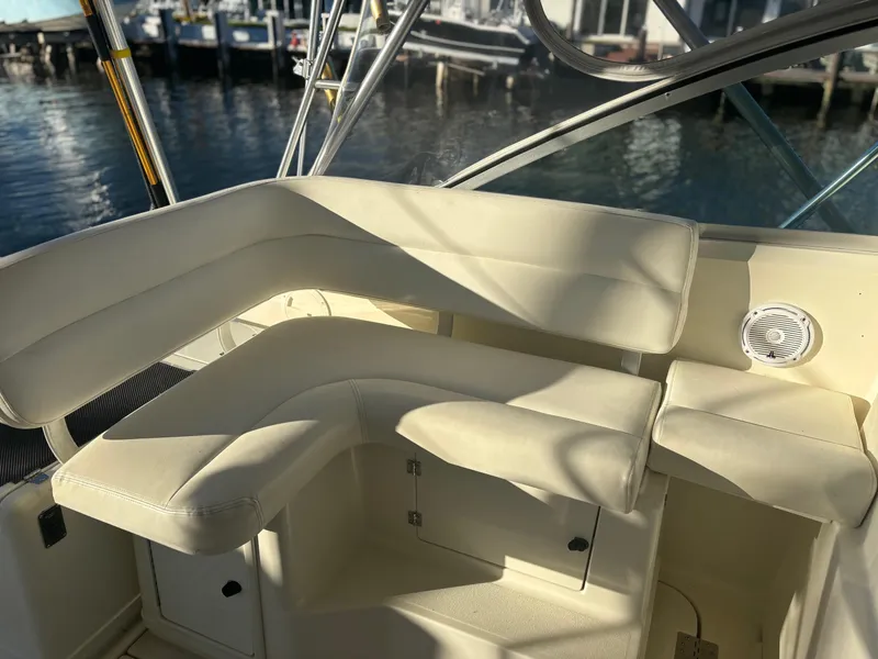 Slide: The Image of 2000 Pursuit 3400 Express boat interior with white seating and waterfront view. - 18