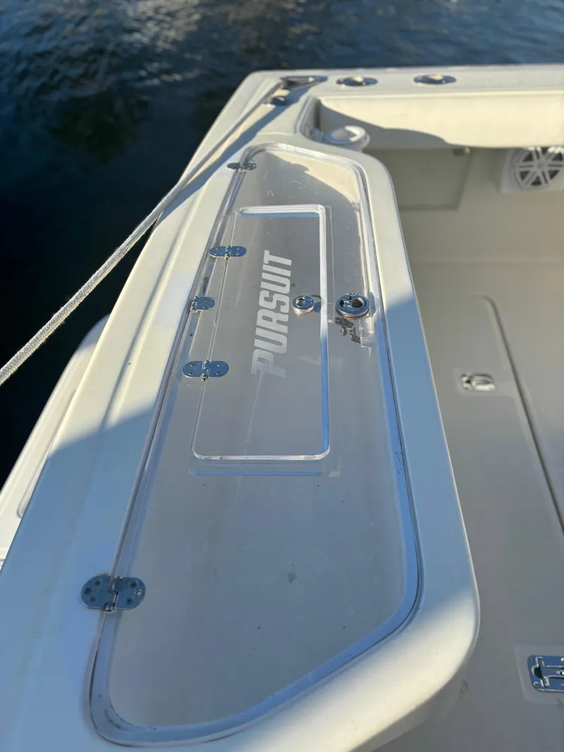 Slide: The Image of 2000 Pursuit 3400 Express boat deck detail with tower, featuring sleek design and clear panel. - 19