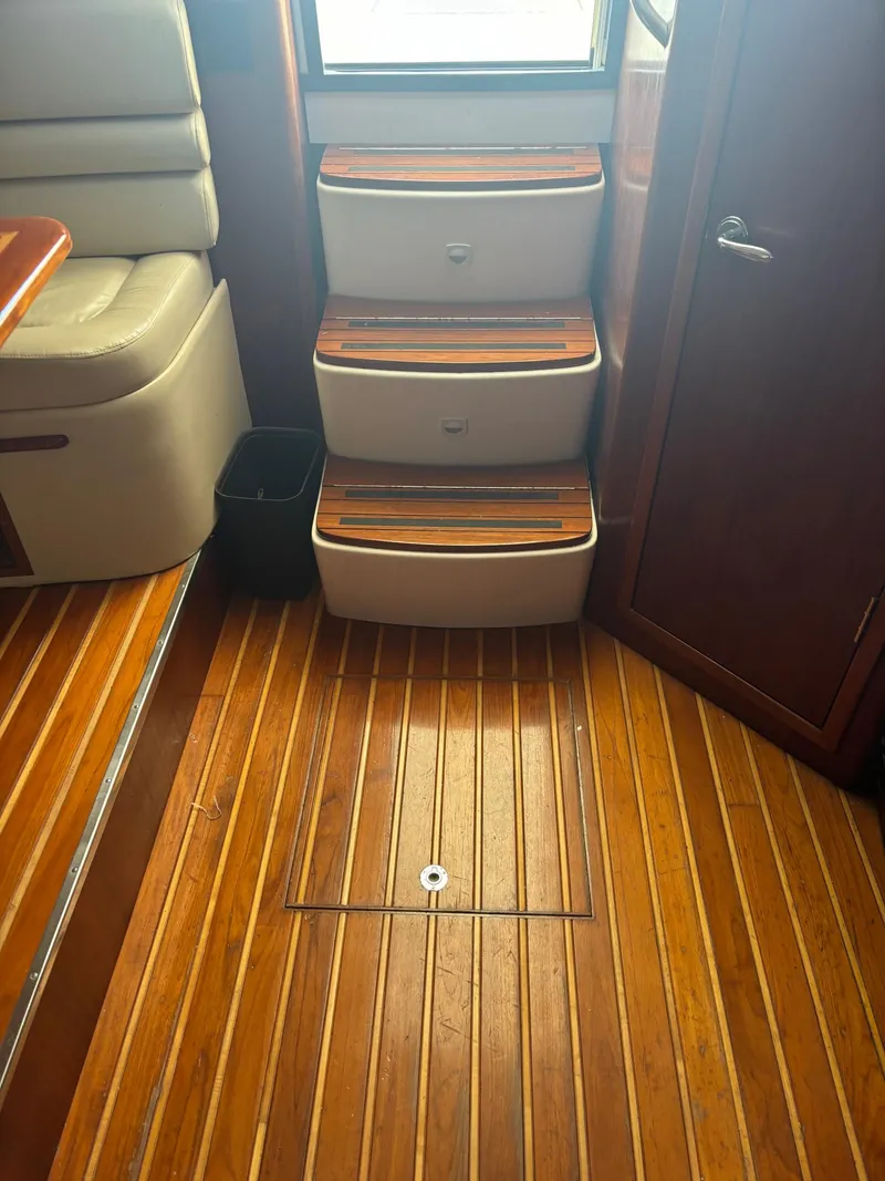 Slide: The Image of Interior of 2000 Pursuit 3400 Express boat with wooden flooring and steps. - 20