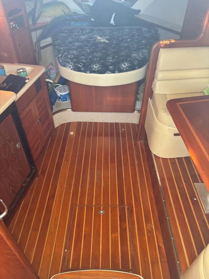 Slide: The Image of Interior of 2000 Pursuit 3400 Express boat with wooden flooring and cozy seating. - 21