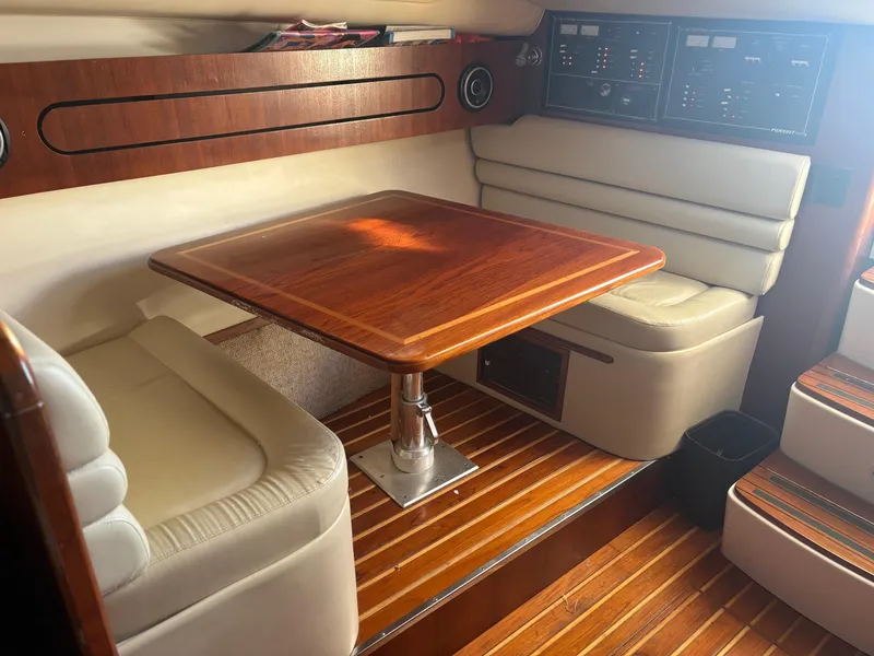 Slide: The Image of Interior of 2000 Pursuit 3400 Express boat with wooden table and cushioned seating. - 24