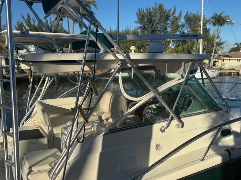 Slide: The Image of 2000 Pursuit 3400 Express boat with tower, docked in a sunny marina. - 3