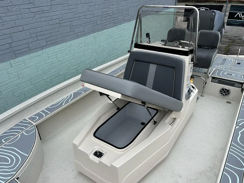 Slide: The Image of 2025 Xpress X23 Bay Lounge boat with open storage compartment and seating. - 6