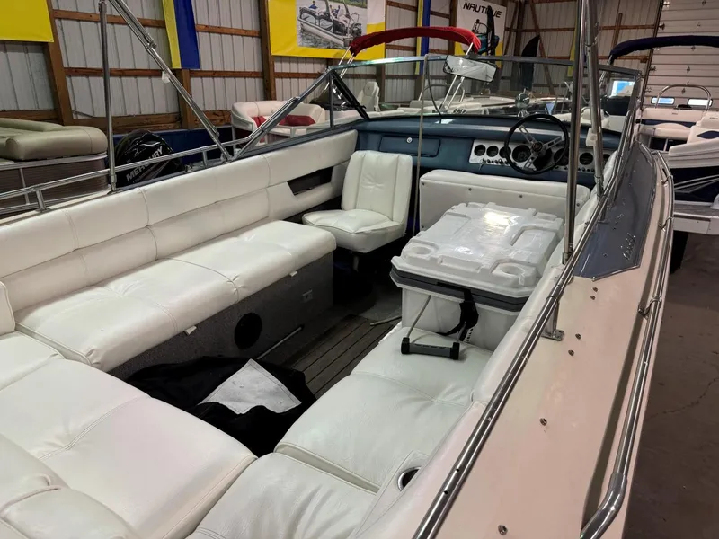 Slide: The Image of 1985 Coronado Cardel boat with white seating, indoor storage, and steering wheel. - 17