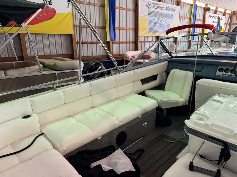 Slide: The Image of 1985 Coronado Cardel boat interior with white seating in a showroom. - 3