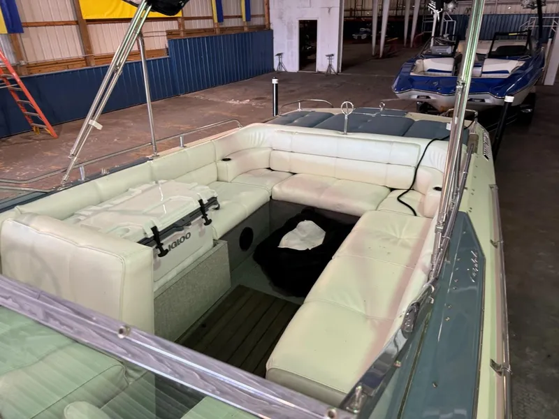 Slide: The Image of 1985 Coronado Cardel boat interior with white seating in a warehouse setting. - 9