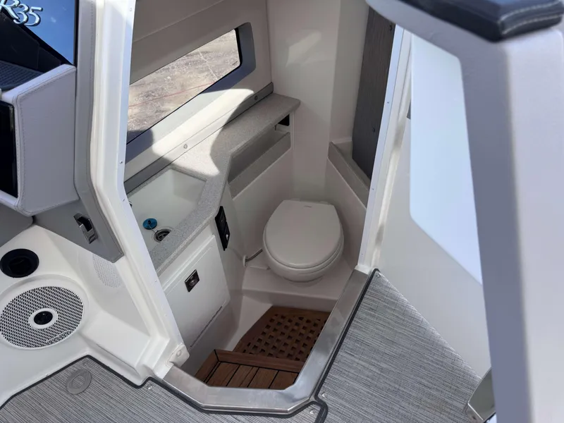 Slide: The Image of Interior of 2025 Cobalt R35 boat featuring a compact bathroom with toilet and sink. - 17