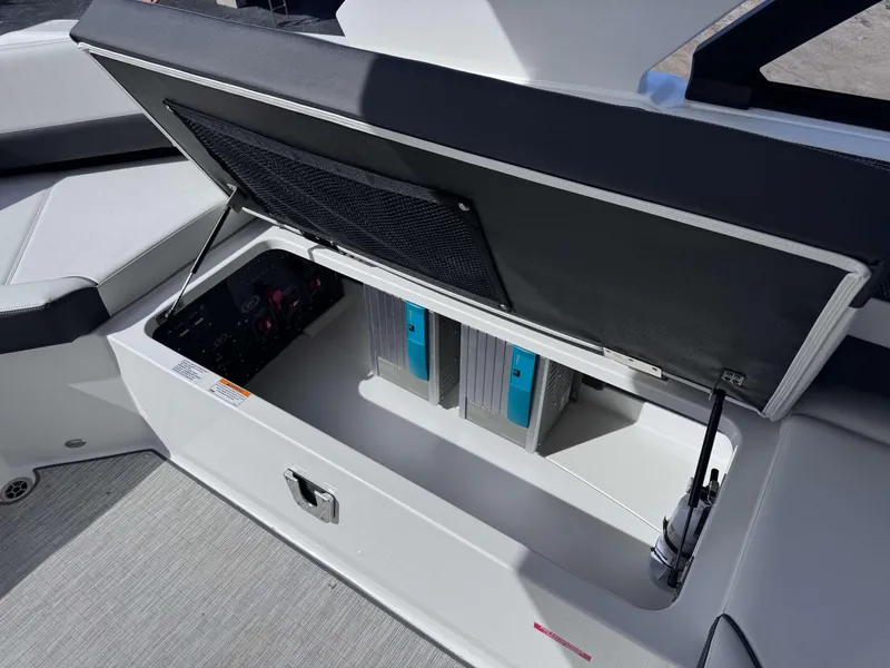 Slide: The Image of 2025 Cobalt R35 boat storage compartment with open lid, revealing interior components. - 23