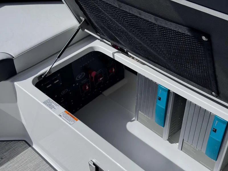 Slide: The Image of Open storage compartment in 2025 Cobalt R35 boat, showing electrical components and wiring. - 24