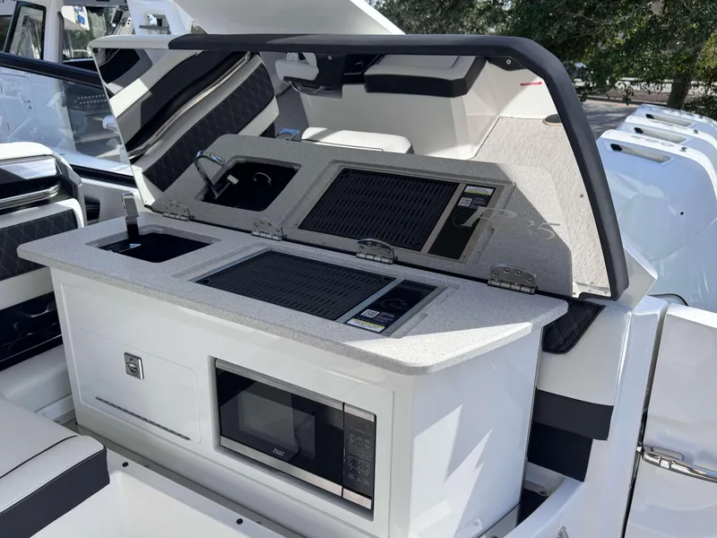 Slide: The Image of Cobalt R35 2025 boat interior with kitchenette, featuring grill and microwave. - 30
