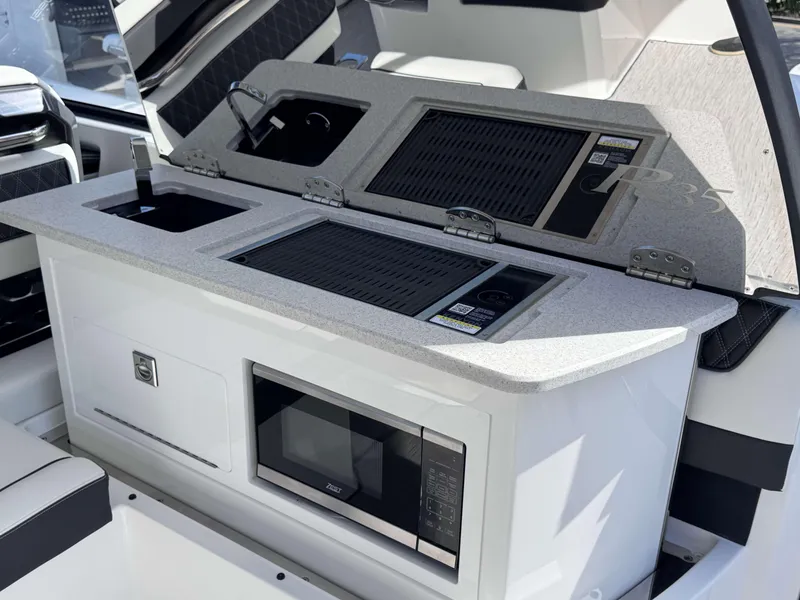 Slide: The Image of 2025 Cobalt R35 boat interior with kitchenette, featuring grill and microwave. - 32