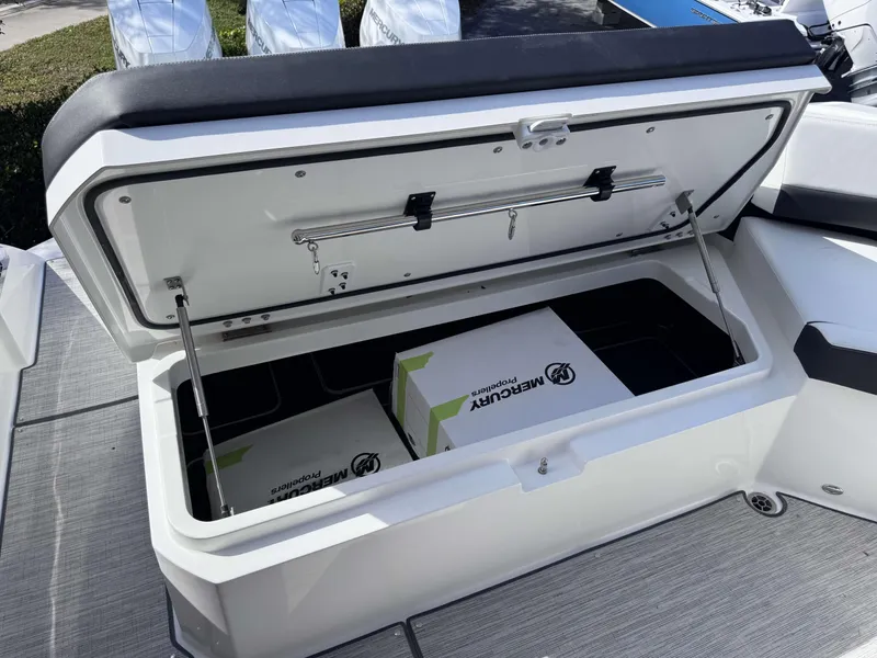 Slide: The Image of Open storage compartment on 2025 Cobalt R35 boat with Mercury box inside. - 33