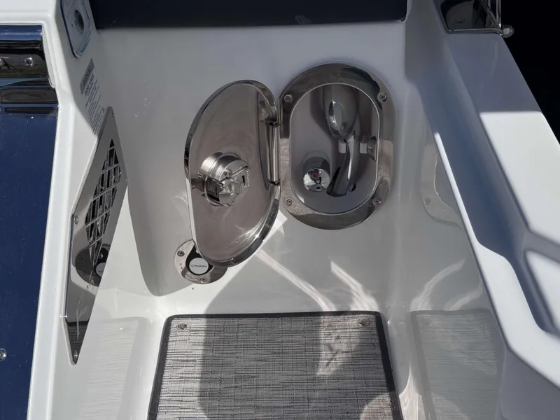 Slide: The Image of Cobalt R35 2025 boat fuel compartment with stainless steel cover and textured mat. - 38