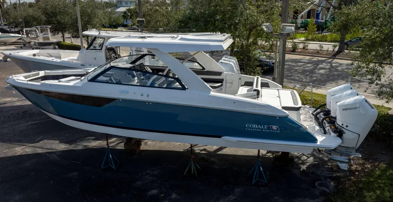 Slide: The Image of 2025 Cobalt R35 boat, blue and white, on display with Mercury outboard engines. - 6