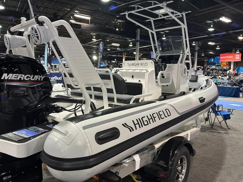 Slide: The Image of 2025 Highfield Sport 560 boat displayed indoors with Mercury engine. - 15