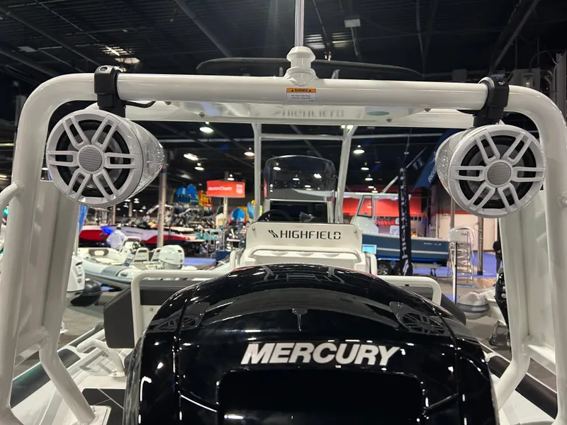 Slide: The Image of 2025 Highfield Sport 560 boat with Mercury engine and speakers, showcased indoors. - 7