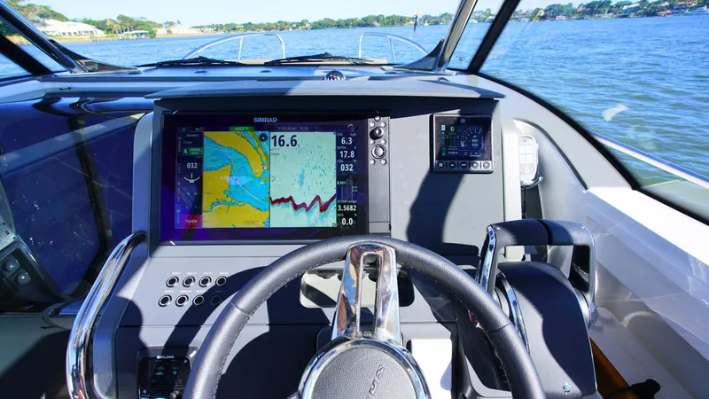 Slide: The Image of Nimbus T9 #165 boat dashboard with navigation display, steering wheel, and water view, 2025 model. - 10