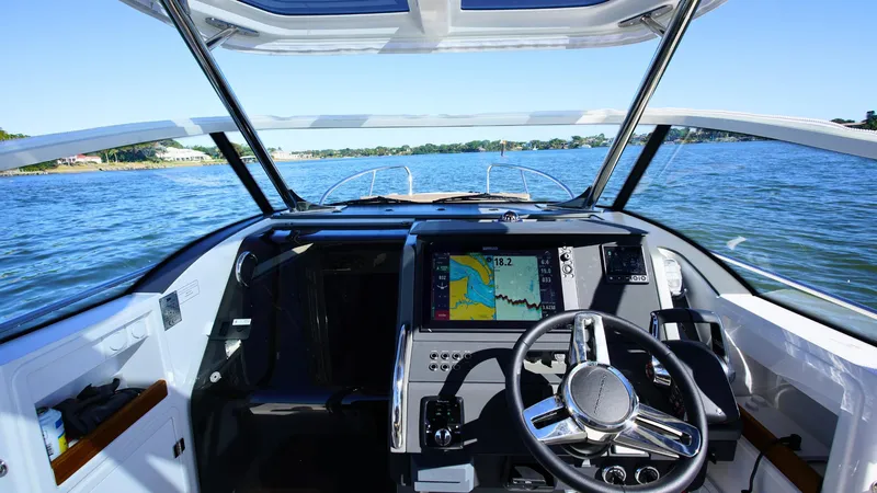 Slide: The Image of Nimbus T9 #165 boat cockpit with navigation system, steering wheel, and open water view. - 8