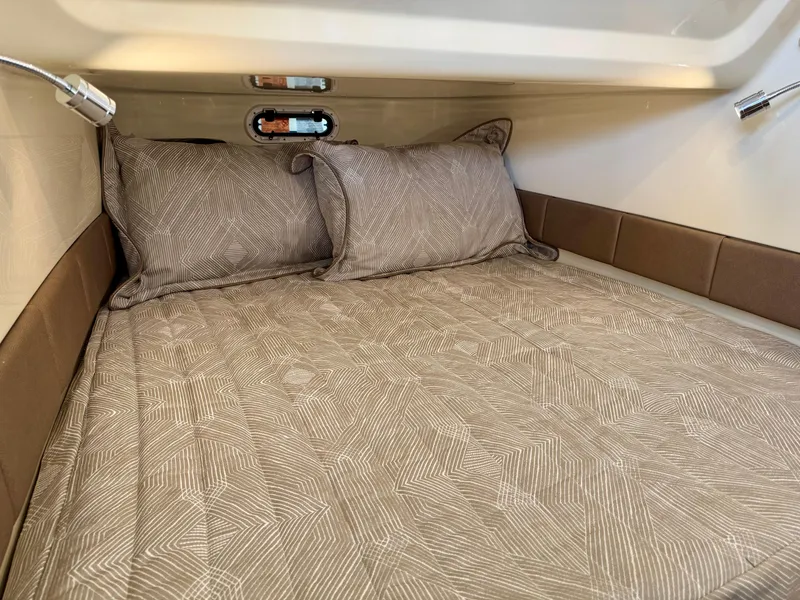 Slide: The Image of 2022 Chris-Craft Catalina 30 cabin interior with patterned bedding and pillows. - 34