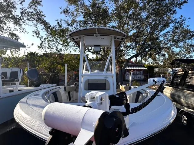 Slide: The Image of 2022 Tidewater 210 LXF boat with trolling motor, docked under trees. - 18