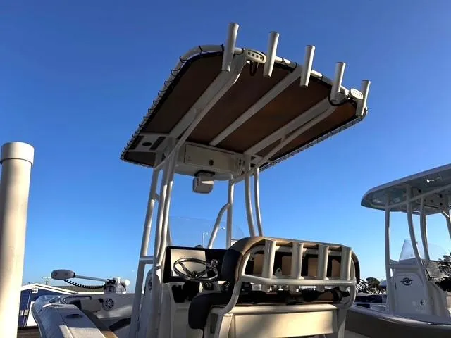 Slide: The Image of 2022 Tidewater 210 LXF boat with T-top and rod holders under clear blue sky. - 7