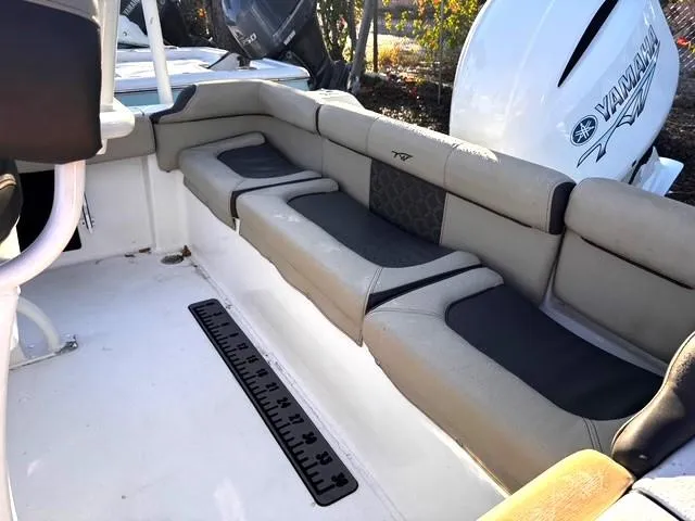 Slide: The Image of 2022 Tidewater 210 LXF boat interior with cushioned seating and Yamaha engine. - 9