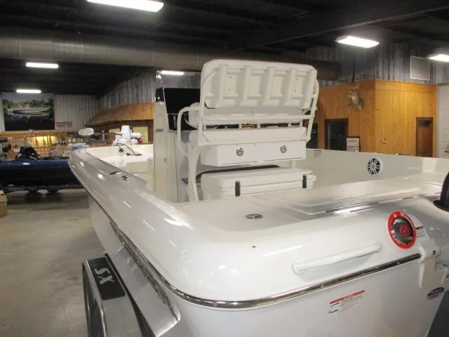 Slide: The Image of 2025 Skeeter SX2350 boat in showroom, rear view with seating and storage. - 12