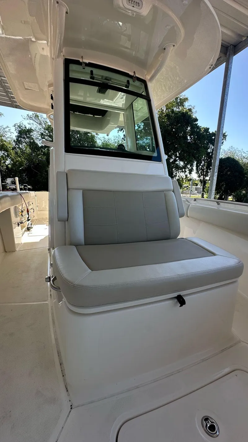 Slide: The Image of 2023 Boston Whaler 250 Outrage boat interior with cushioned seating and window. - 7
