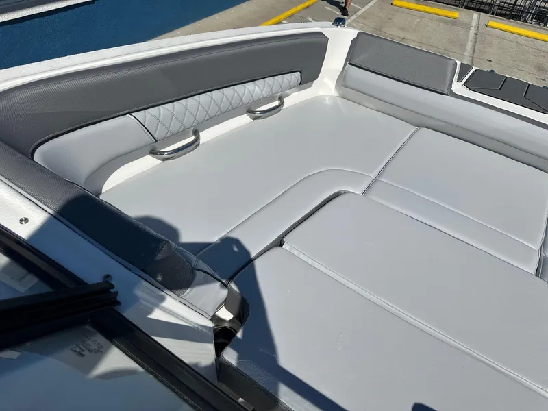 Slide: The Image of 2025 Bayliner D22 boat interior with gray and white cushioned seating. - 10