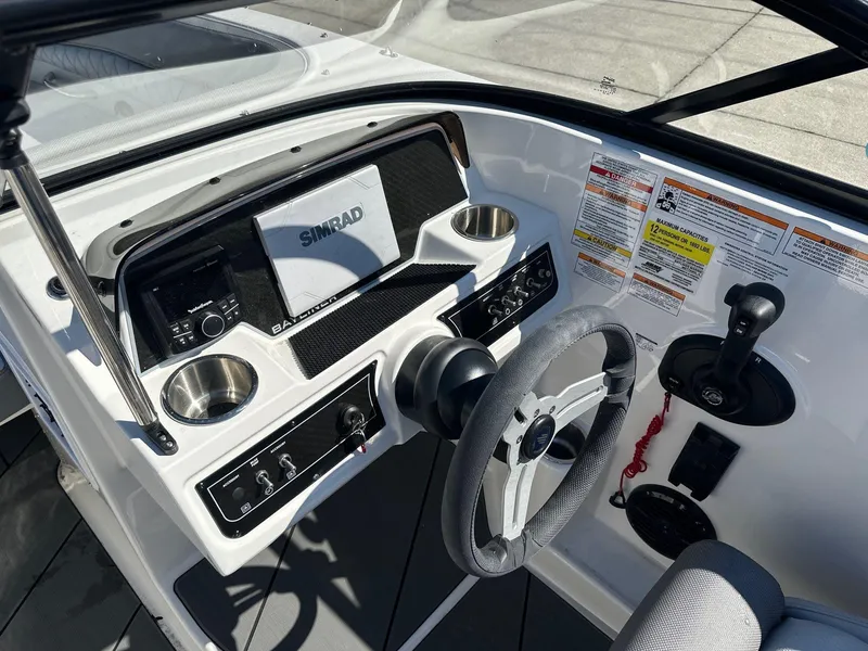 Slide: The Image of 2025 Bayliner D22 boat dashboard with steering wheel, Simrad display, and control panel. - 12