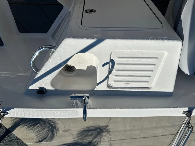 Slide: The Image of 2025 Bayliner D22 boat deck with storage compartment and handle. - 16