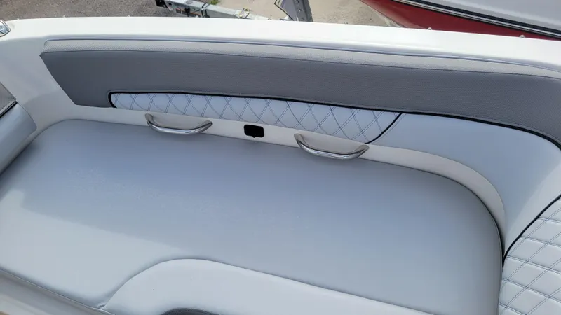 Slide: The Image of 2025 Bayliner D22 boat interior with gray cushioned seating and quilted backrest. - 23