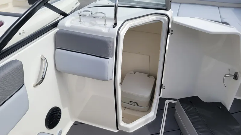 Slide: The Image of 2025 Bayliner D22 boat interior with open storage compartment and portable toilet. - 44