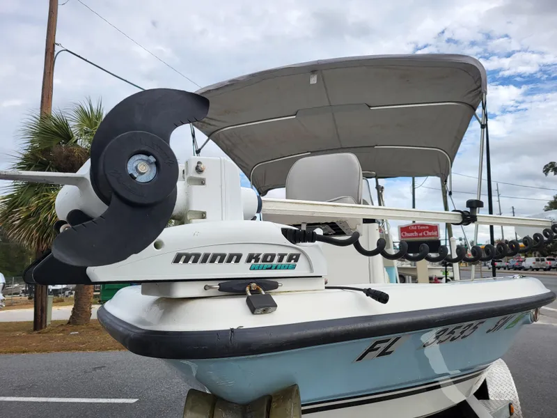 Slide: The Image of 2006 Triton 190 LTS boat with Minn Kota trolling motor, parked on roadside. - 2