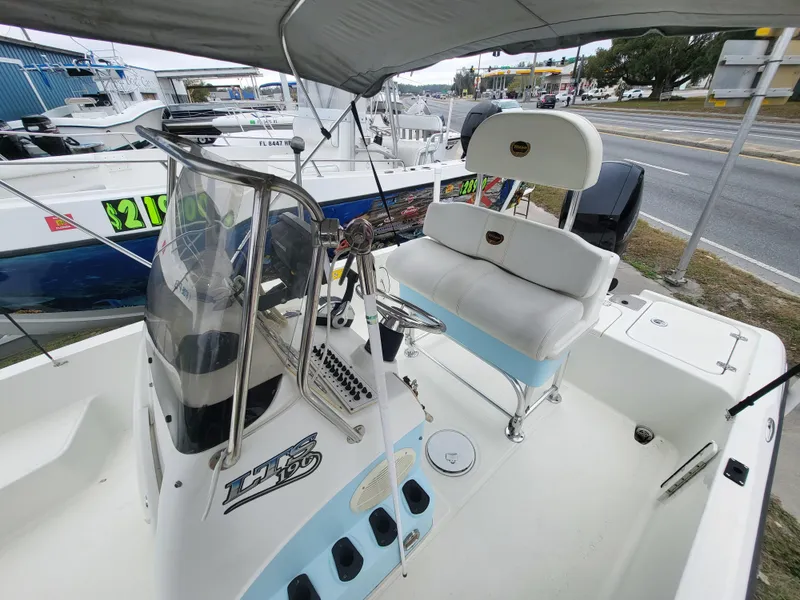 Slide: The Image of 2006 Triton 190 LTS boat with seating and console, parked near road. - 7