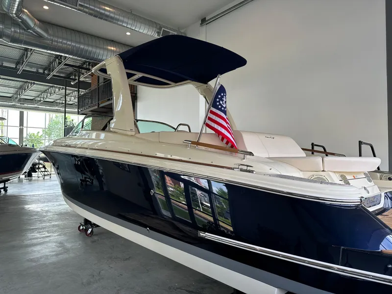 Slide: The Image of 2024 Chris-Craft Launch 28 GT boat with American flag in showroom. - 20