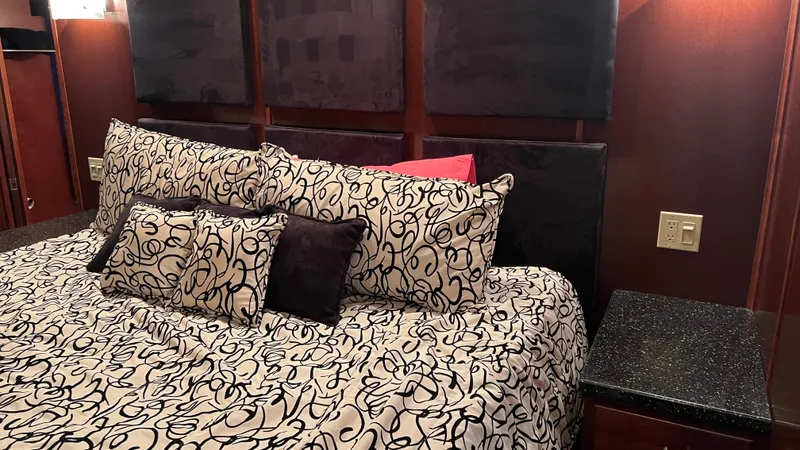 Slide: The Image of Luxurious bedroom interior on 2008 Monticello River Yacht with patterned bedding and wood paneling. - 16