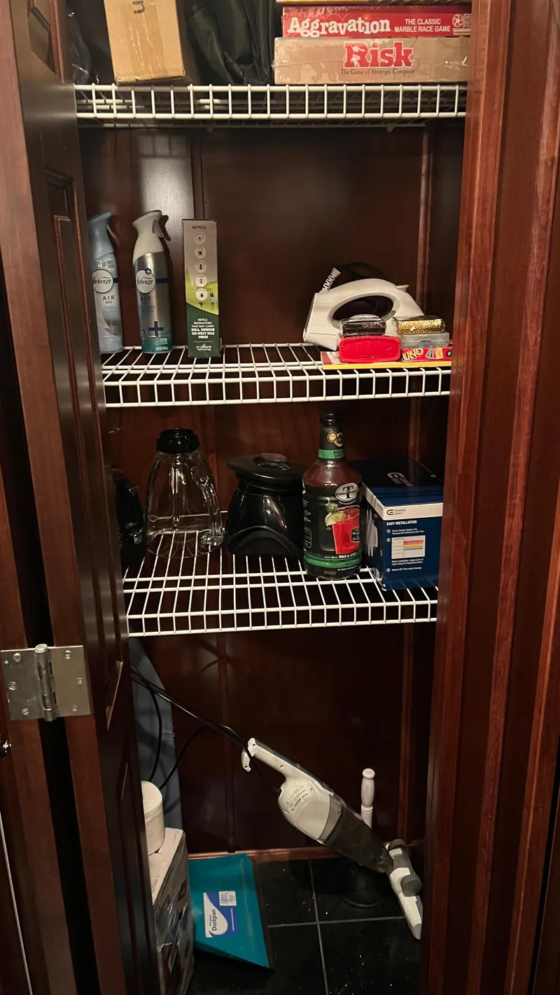 Slide: The Image of Closet with cleaning supplies, board games, and household items on wire shelves. - 29