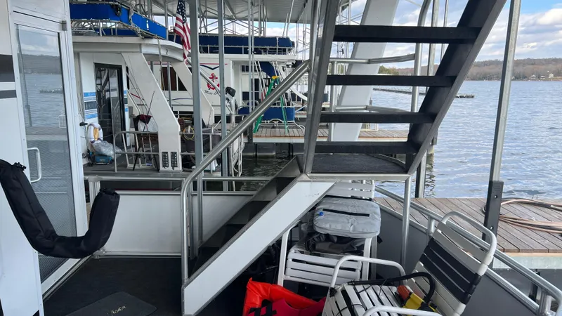 Slide: The Image of 2008 Monticello River Yacht docked, featuring outdoor seating and stairway with lake view. - 57