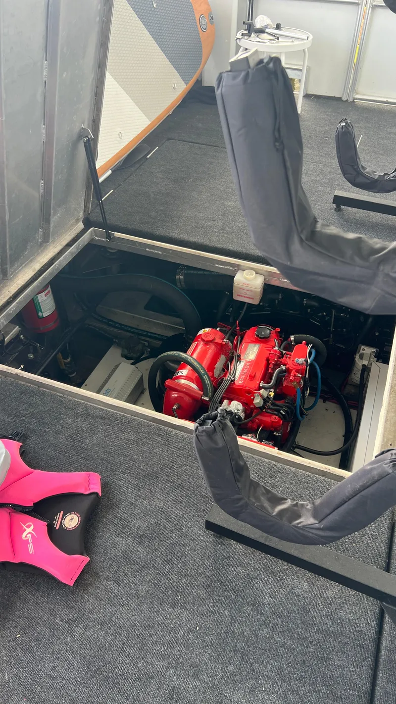 Slide: The Image of Engine compartment of 2008 Monticello River Yacht with visible red engine and safety gear. - 81