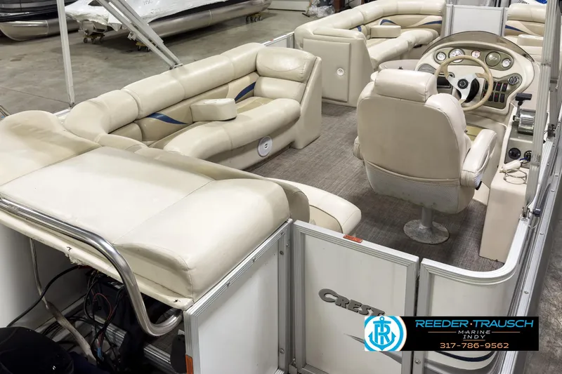 Slide: The Image of 2006 Crest Caribbean 2570 pontoon boat interior with beige seating and steering console. - 11